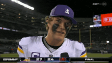 a football player wearing a purple hat and a jersey with the letter c on it