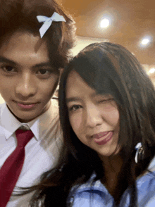 a man and a woman are posing for a picture with the woman sticking her tongue out