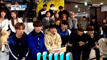 a group of people sitting in front of a mbc sign