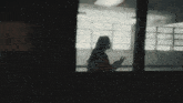 a silhouette of a person standing in a room with a lot of windows