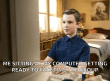 a young boy sits at a desk with a computer and says he is sitting at his computer getting ready to facetime