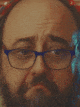 a man with glasses and a beard is looking at the camera