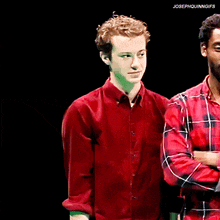 a man in a red shirt is standing next to another man