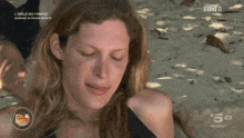 a woman laying on a beach with giorno 13 on the bottom right