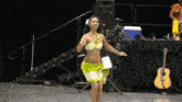 a woman in a bikini is dancing in front of a stage with a sign that says ' ii ' on it