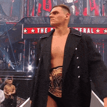 a wrestler stands in front of a sign that says " the general "