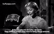 a woman is sitting at a table in a black and white photo with a quote from a movie .