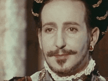 a close up of a man 's face with a beard and earrings
