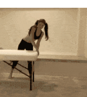 a woman is leaning on a massage table in a black and white photo