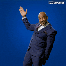 a man in a suit is pointing up with fox deportes written on the bottom