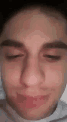 a close up of a young man 's face with his eyes closed and his mouth open .