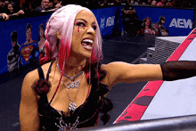 a woman in a wrestling ring with a sign that says aew behind her