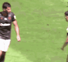 a man in a castrol shirt is walking on a field