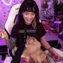 a woman sits in an akr chair with a cat