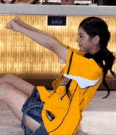 a woman wearing a yellow shirt that says ' ucsd ' on it