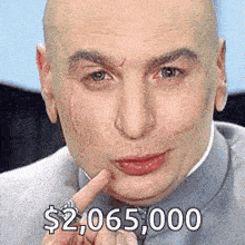 a bald man with a ring on his finger is pointing to his face and says $ 2,065,000