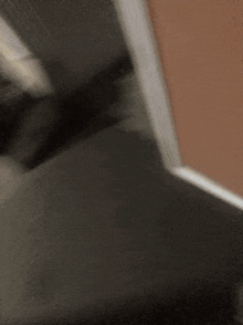 a blurred image of a person standing next to a wall