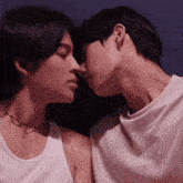 two men are kissing each other on the forehead in a dark room .