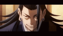 a close up of a man with long hair and earrings smiling