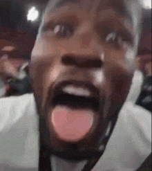 a close up of a man with his tongue out .