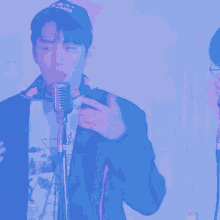 a man singing into a microphone while wearing a shirt that says " ab " on it