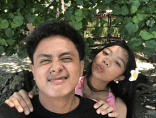 a boy and a girl are posing for a picture
