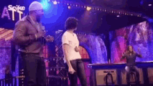 a group of people are dancing on a stage at a concert .