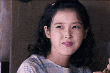 a close up of a woman 's face with a plaid shirt