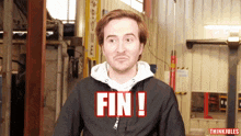 a man in a black jacket has the word fin written on his chest