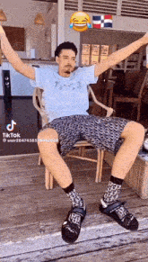 a man is sitting in a chair with his arms outstretched and a laughing face above him