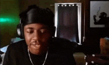 a man wearing headphones and a chain is making a funny face .