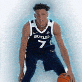 a basketball player wearing a butler jersey is holding a basketball