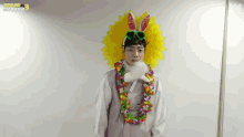 a man wearing a flower lei and bunny ears looks at the camera