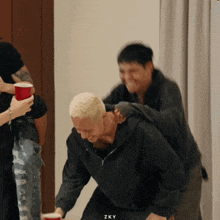 a man in a black hoodie is being piggybacked by another man in a black hoodie