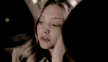 a woman is touching her face with her hand