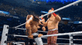 two men are wrestling in a wrestling ring with ropes .