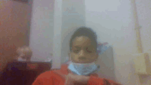 a young boy wearing a red shirt and a mask
