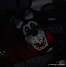 a close up of a cartoon character 's face in the dark with a glowing mouth .
