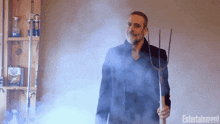 a man is holding a pitchfork in a room with entertainment written on the bottom