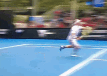 a blurry picture of a tennis player playing on a blue court