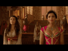 a woman in a pink dress is standing next to another woman