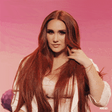 a woman with long red hair is wearing a white top