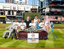 a group of astros baseball players pose in front of a coffin with a sign that says built for this
