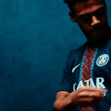 a man wearing a blue shirt with a circle on the front