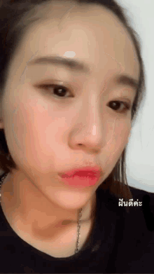 a close up of a woman 's face with chinese writing on the bottom right corner