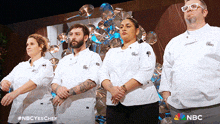 a group of chefs are standing in front of a wall of pots and pans with the nbc logo on the bottom