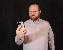 a man wearing glasses is taking a picture of himself with his phone