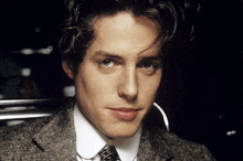 a close up of a man 's face with a suit and tie