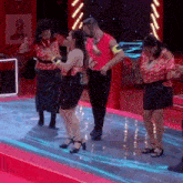 a group of people are dancing on a stage in front of a sign that says cowboy boots