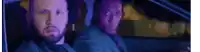 two men are sitting in the back seat of a car .